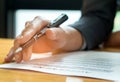 Businessmen holding pens in hand reading documents on the desk,Businessmen holding pens in hand reading contract documents before