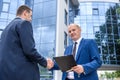 Businessmen making deal and handshaking outside building Royalty Free Stock Photo