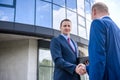 Businessmen making deal and handshaking outside building Royalty Free Stock Photo