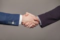 Businessmen making handshake on grey background. Business cooperation, agreement and partnership concept Royalty Free Stock Photo