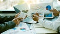 Businessmen meeting in the office and calculating their finances with a calculator, with the man holding a pen pointing Royalty Free Stock Photo