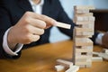 Businessmen picking wood blocks to fill the missing dominoes. Growing business concept