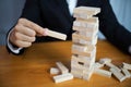 Businessmen picking wood blocks to fill the missing dominoes. Growing business concept