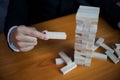 Businessmen picking wood blocks to fill the missing dominoes. Growing business concept