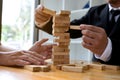 Businessmen picking wood blocks to fill the missing wood blocks and protect wood blocks to fail. Growing business concept