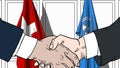 Businessmen or politicians shake hands against flags of Switzerland and United Nations. Official meeting or cooperation