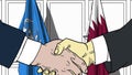 Businessmen or politicians shake hands against flags of United Nations and Qatar. Official meeting or cooperation