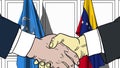 Businessmen or politicians shake hands against flags of United Nations and Venezuela. Official meeting or cooperation