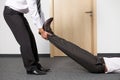 Businessmen pulling colleague's leg at office