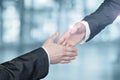 Businessmen reach out to each other to shake hands Royalty Free Stock Photo