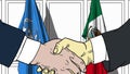 Businessmen or politicians shake hands against flags of United Nations and Mexico. Official meeting or cooperation