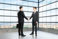 Businessmen shake hands in empty loft room