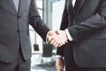 Businessmen shake hands in loft conference room