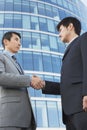 Businessmen Shaking Hands Against Office Building Royalty Free Stock Photo