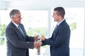 Businessmen shaking hands and exchanging money Royalty Free Stock Photo