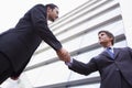Businessmen shaking hands outside office building Royalty Free Stock Photo