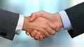 Businessmen shaking hands on the table with blurred documents and a computer in the office Royalty Free Stock Photo