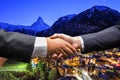 Businessmen shaking hands on Zermatt, Switzerland background
