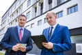 Businessmen signing contract with euro banknotes outdoors