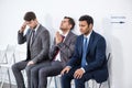 Businessmen sitting in queue and waiting for interview in office