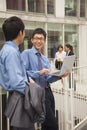 Businessmen smiling and working together outside with laptop Royalty Free Stock Photo