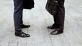 Businessmen standing face to face, closeup on feet in leather shoes, formalwear Royalty Free Stock Photo