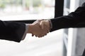 businessmen in suit shaking hands beside window - business teamwork, cooperation concept Royalty Free Stock Photo