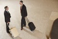 Businessmen With Suitcases By Luggage Carousel In Airport Royalty Free Stock Photo