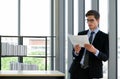 Businessmen in suits and tie reading quarter`s sales report. Morning work atmosphere In a modern office