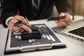 Businessmen use credit cards and calculator to conduct financial transactions through laptop.