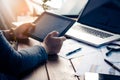 Businessmen are using their mobile to work with a laptop.