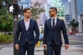 Businessmen walk in the street. Two businessmen walking and talking at office building. Two american businessmen in Royalty Free Stock Photo