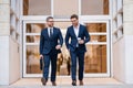 Businessmen walk in the street. Two businessmen walking and talking at office building. Two american businessmen in Royalty Free Stock Photo