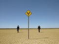 Businessmen Walking Past Road Sign In Desert Royalty Free Stock Photo