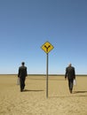 Businessmen Walking Past Road Sign In Desert Royalty Free Stock Photo