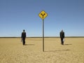 Businessmen Walking Past Road Sign In Desert Royalty Free Stock Photo