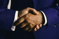 Businessmen wear smart suits. Business deal and agreement concept. Male hands shaking tight. Handshake on light grey Royalty Free Stock Photo