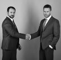 Businessmen wear smart suits and ties. Men with beard and serious faces make deal or agreement. CEOs shake hands on blue Royalty Free Stock Photo