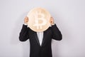 Businessnan holding big golden bitcoin on pink background. Crypto currency, virtual money, internet and economics