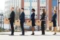 Businesspeople With Boxes Standing In A Line