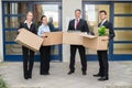 Businesspeople With Cardboard Box Moving Into New Office