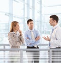 Businesspeople chatting in modern office lobby