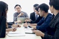 Businesspeople at conference, seriously senior businessman pointing at someone to answer question at group meeting. Elderly boss