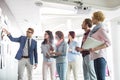 Businesspeople discussing over documents on wall in creative office Royalty Free Stock Photo