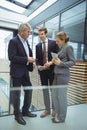 Businesspeople discussing over electronic devices in the passageway Royalty Free Stock Photo