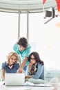 Businesspeople discussing over laptop at table in creative office Royalty Free Stock Photo