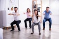 Businesspeople Doing Sit-ups In Office