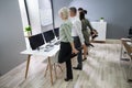 Businesspeople Doing Stretching Exercise At Workplace