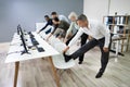 Businesspeople Doing Stretching Exercise At Workplace