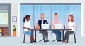 Businesspeople group meeting conference mix race coworkers using laptop sitting at round table modern office interior co Royalty Free Stock Photo